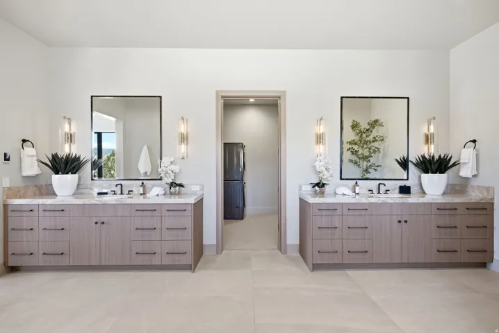 Dual floating vanities with stone countertops, integrated sinks, and matte black fixtures