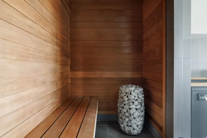 Wood-paneled interior with built-in bench seating and a stone-filled heater