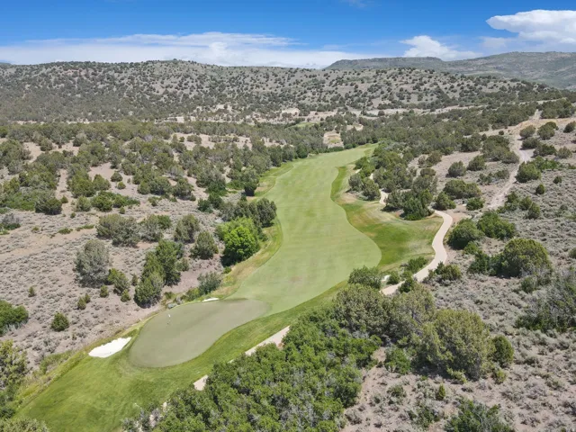 Expansive golf course fairway with a sand trap and putting green