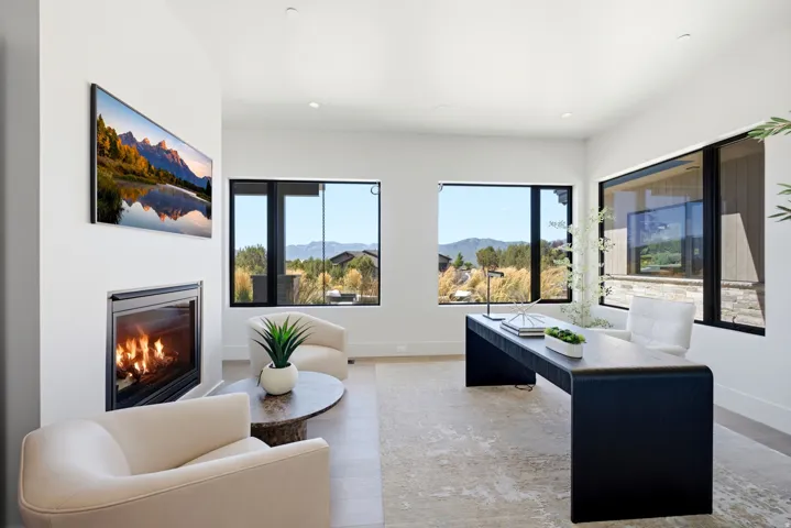 Integrated fireplace, large windows, recessed lighting, white walls, and wood-finish flooring