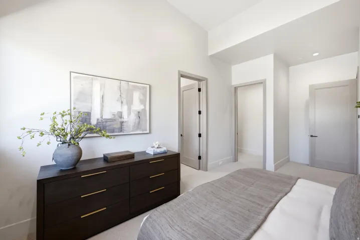 Vaulted ceiling, recessed lighting, neutral wall tones, and light-colored carpeting