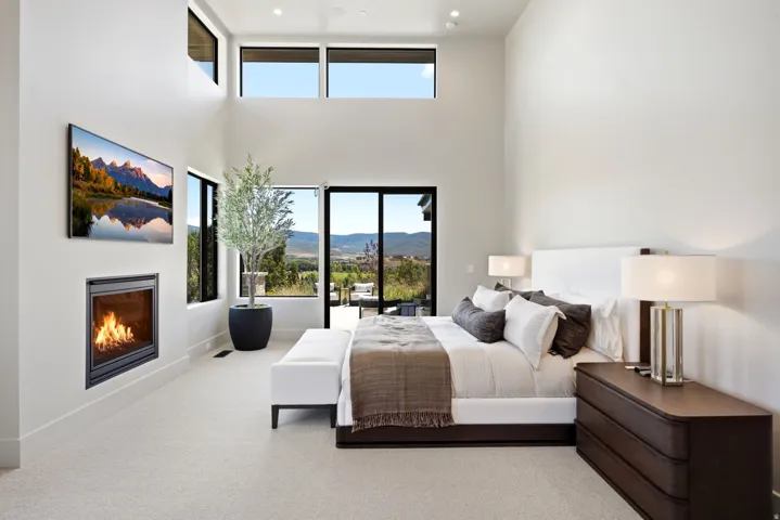 Expansive room with high ceilings, an integrated fireplace, and large windows providing abundant natural light