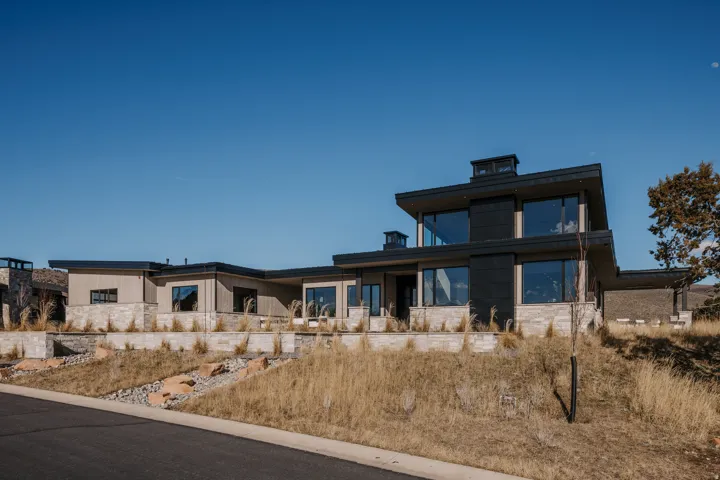 Contemporary architectural design featuring expansive windows, natural stone accents, and a flat roofline