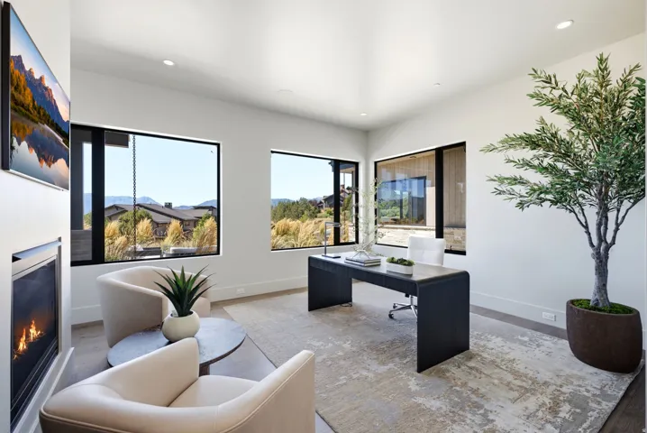 Recessed lighting, large windows, mountain backdrop, built-in fireplace, and high ceilings