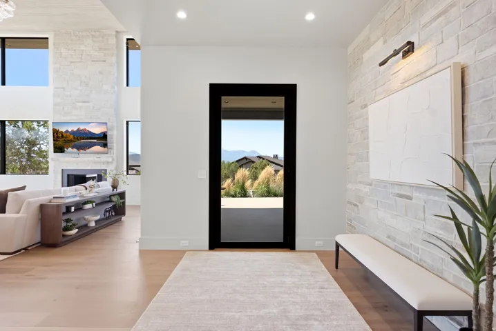 Spacious living area featuring a stone accent wall, wood-finish flooring, and a large fireplace with a built-in entertainment niche