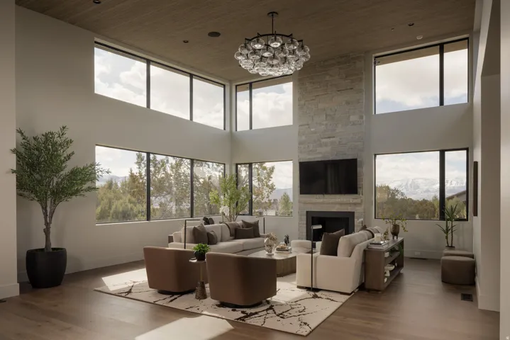 Two-story stone-clad fireplace with hearth, wood-finish flooring, high ceilings with wood-paneling, large picture windows, and a multi-light chandelier