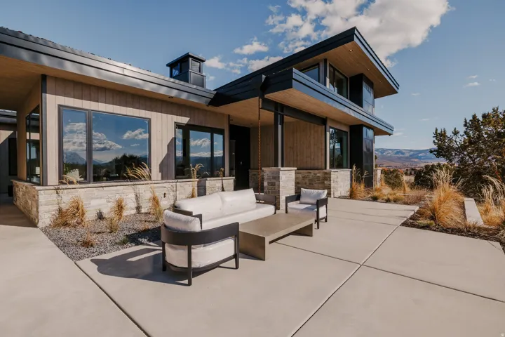 Modern exterior with wood paneling and stone accent base