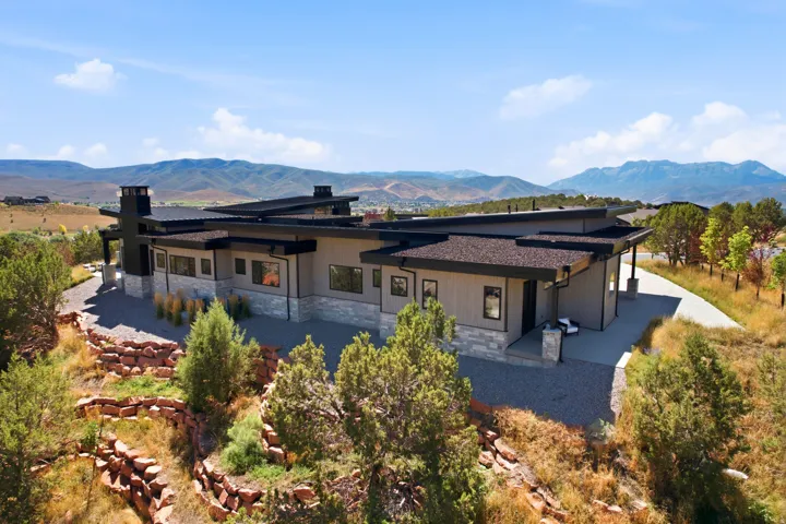 Contemporary exterior with multi-level rooflines, extensive gray siding, and stone accents