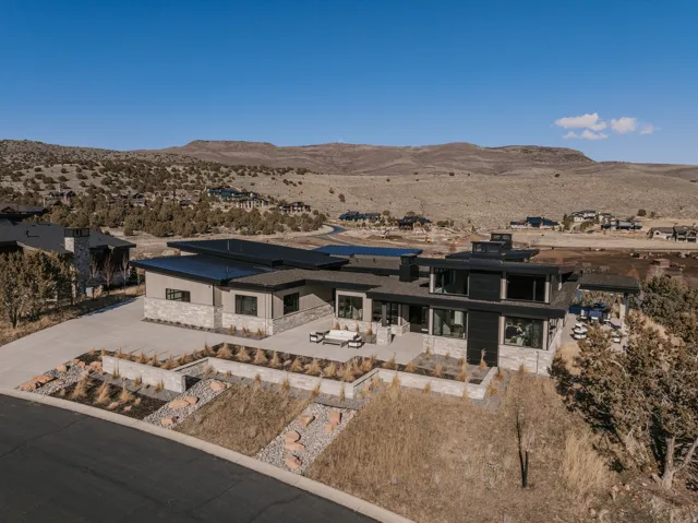 Modern architectural design featuring expansive flat roofs, a multi-textured exterior with stone and horizontal siding, and large format windows