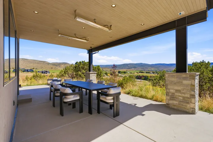 Expansive covered patio featuring a wood-finish ceiling, recessed lighting, and wall-mounted heaters