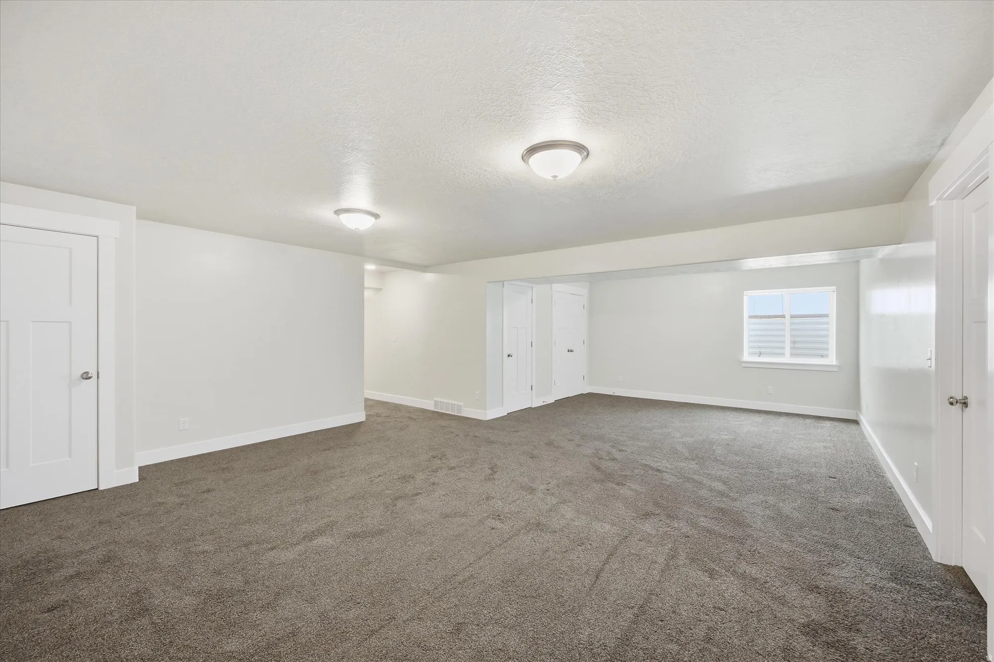 Basement with a textured ceiling and dark carpet