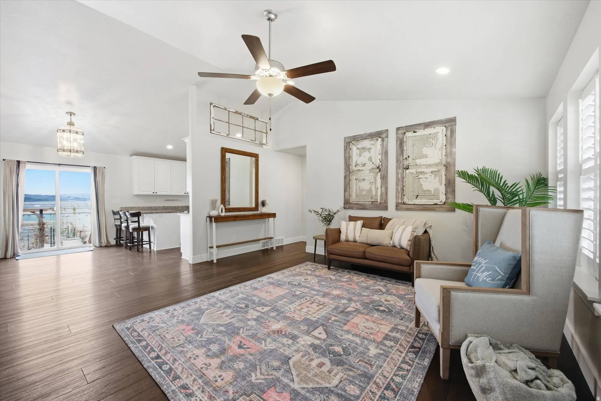 Living area with healthy amount of natural light, a ceiling fan, dark wood finished floors, vaulted ceiling, and recessed lighting