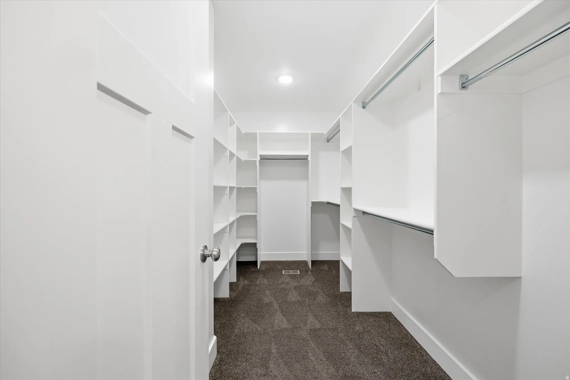 Walk in closet featuring dark carpet