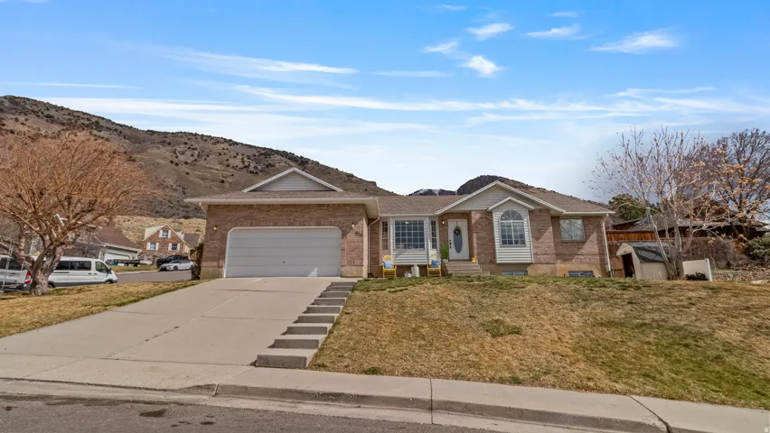 Ranch-style house featuring brick siding, driveway, and a front lawn