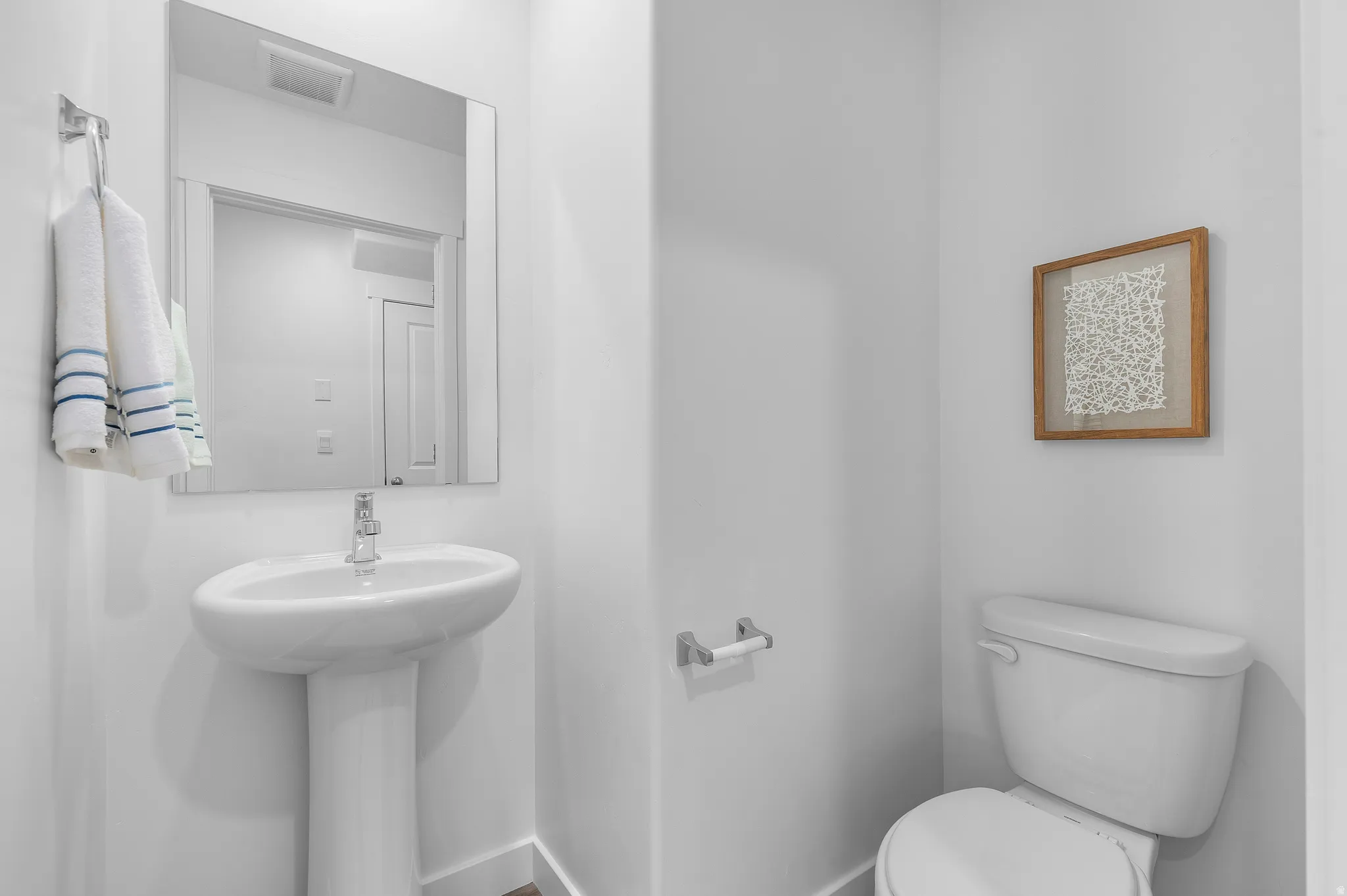 Half bath featuring toilet and baseboards