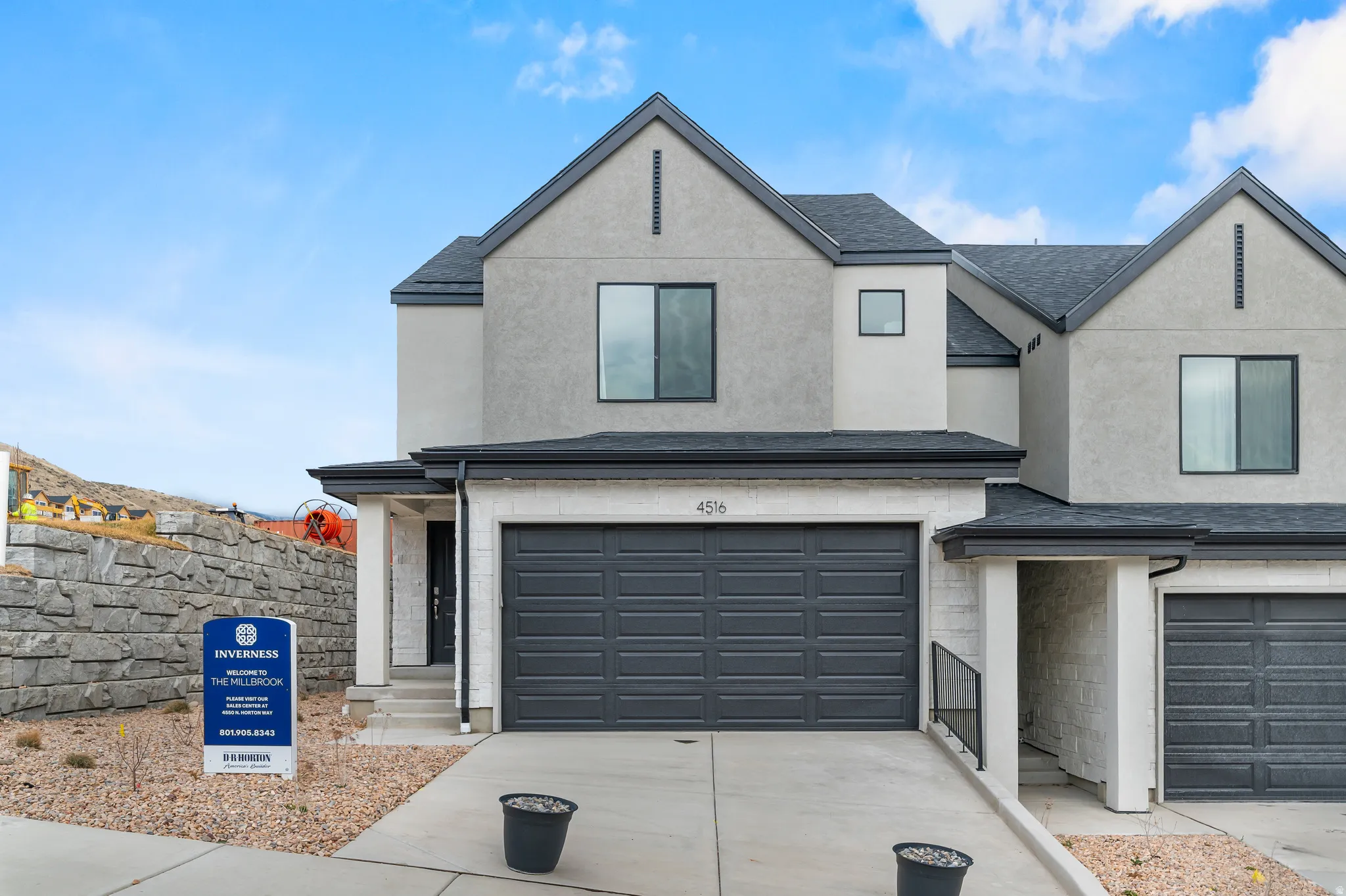 View of front of home with an attached garage, stucco siding, concrete driveway, and roof with shingles