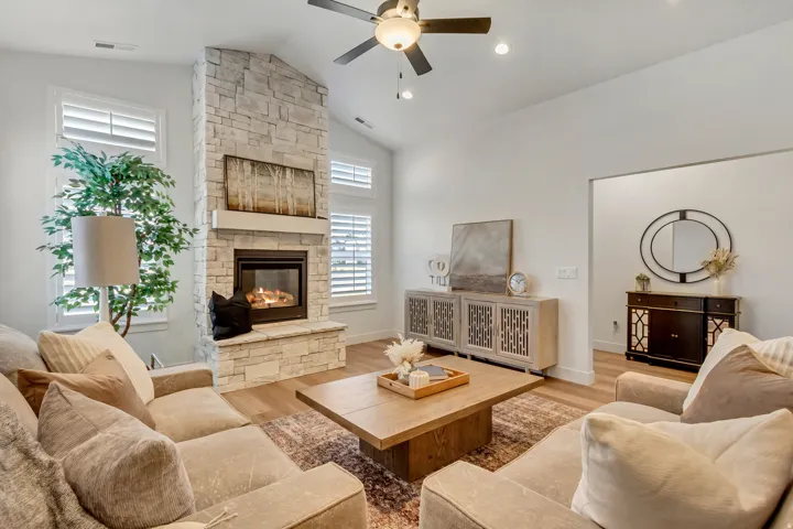 Living room featuring a ceiling fan, wood finished floors, a stone fireplace, and recessed lighting