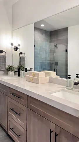 Bathroom featuring double vanity and a shower stall