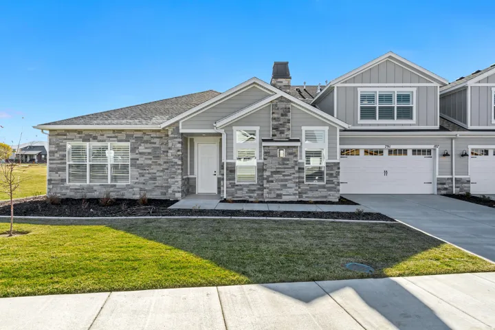Craftsman inspired home with stone siding, a front lawn, a garage, and concrete driveway