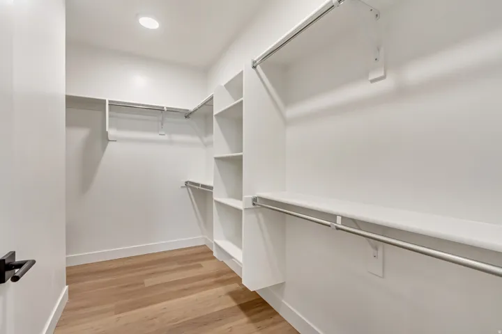 Walk in closet with light wood-type flooring