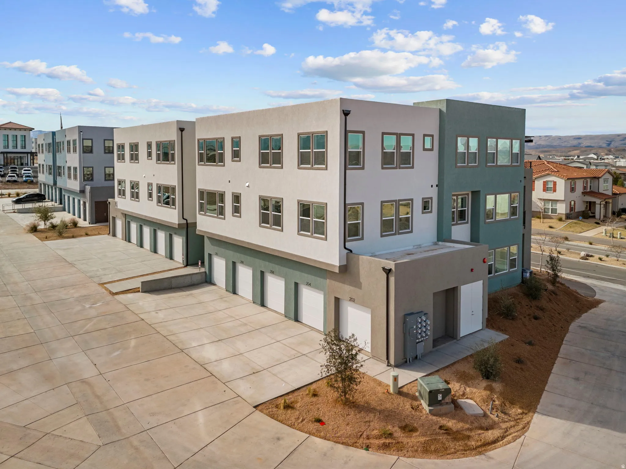 View of property with a garage, driveway, and a residential view
