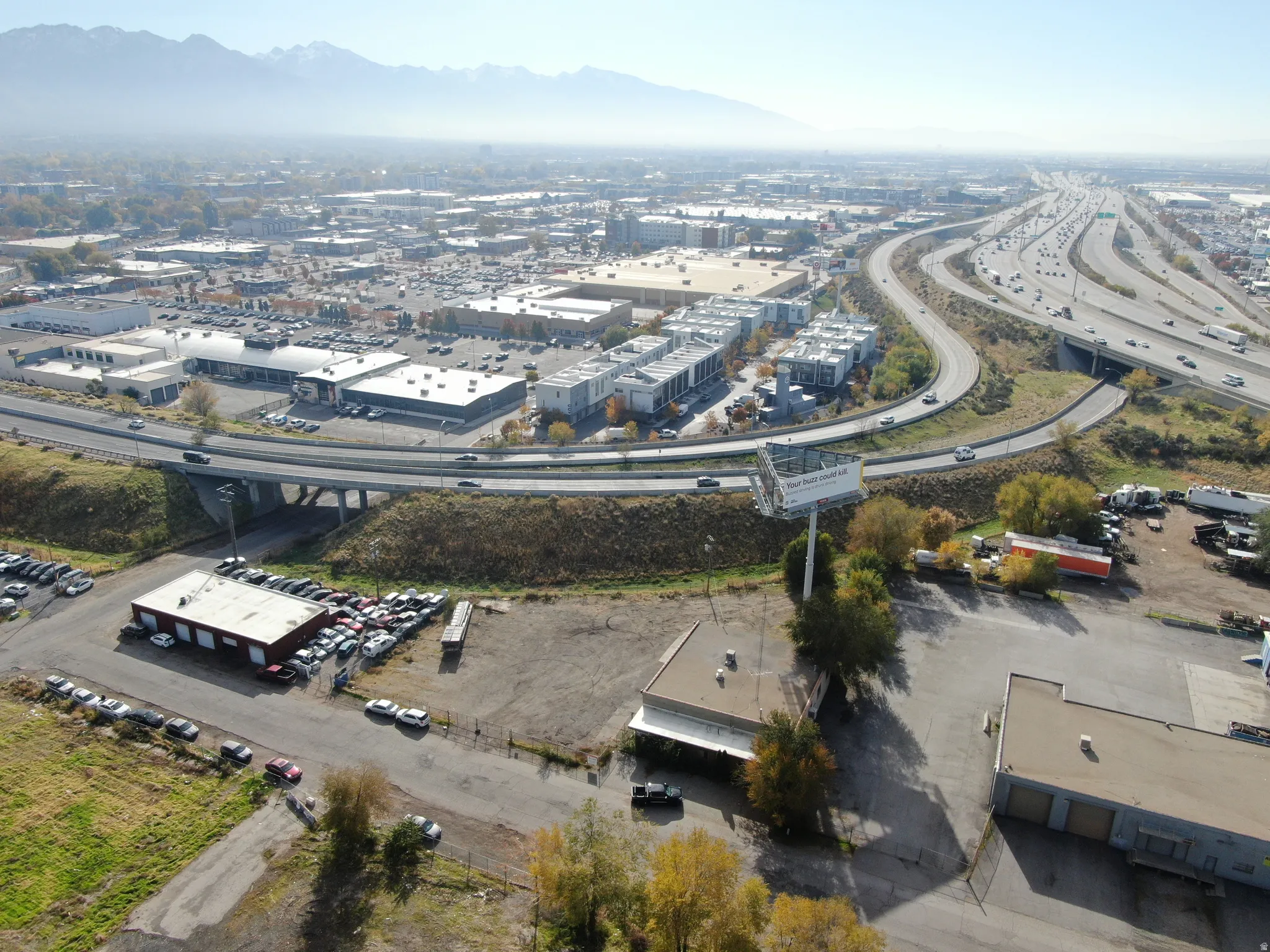 Aerial view of property and surrounding area featuring a mountain backdrop