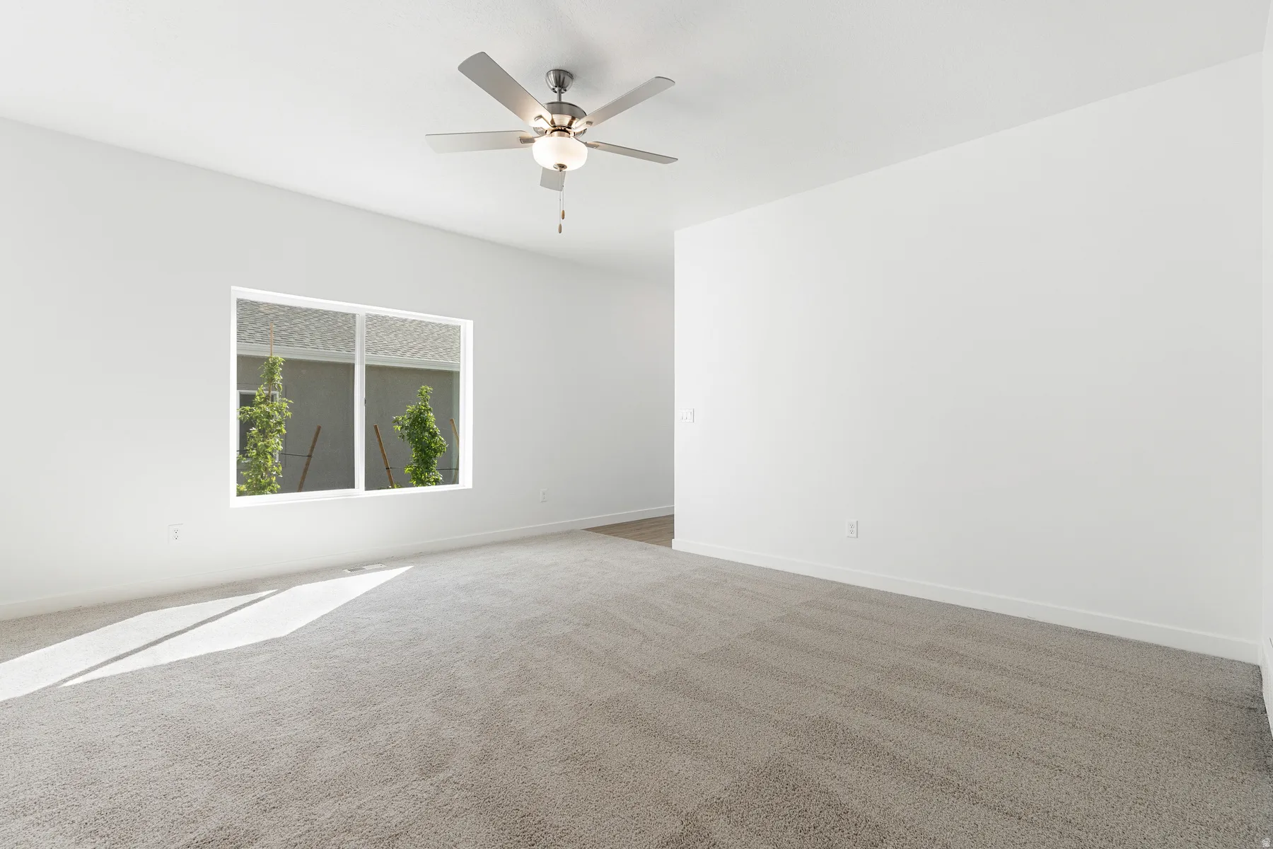 Empty room with carpet flooring and a ceiling fan