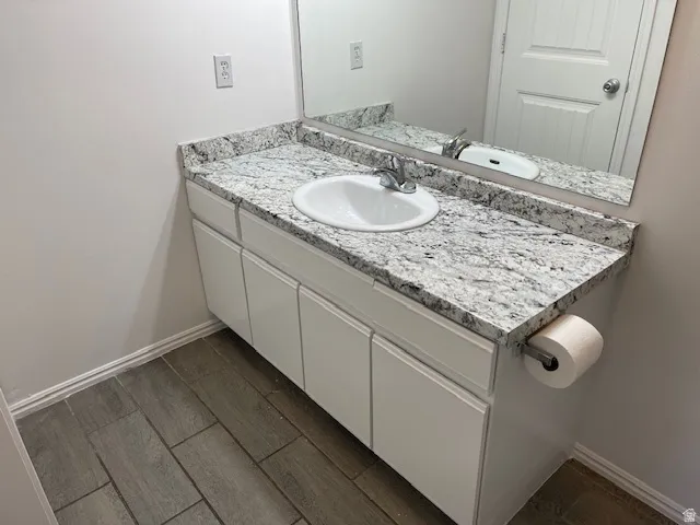 Bathroom featuring vanity and wood finish floors