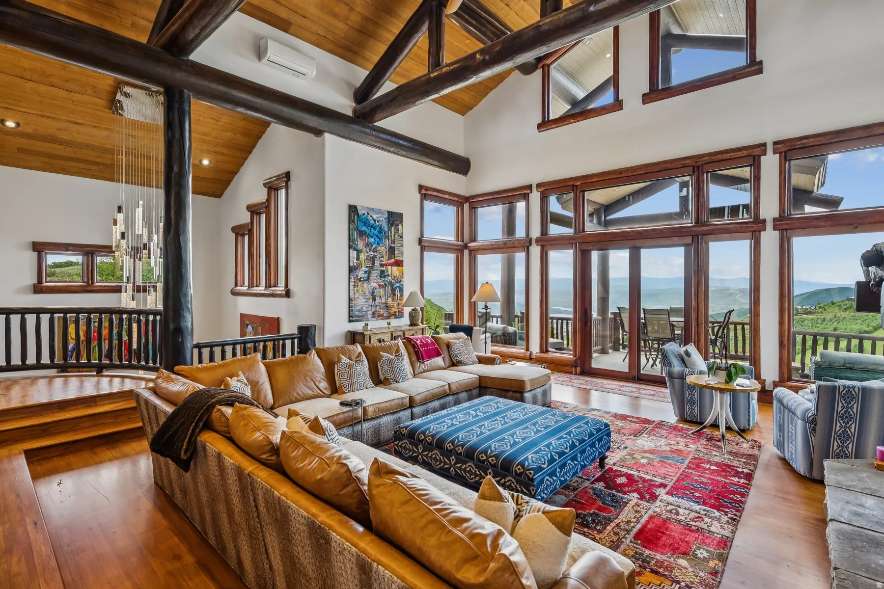Living room with hardwood / wood-style floors, a high wooden beamed ceiling, and hanging lights
