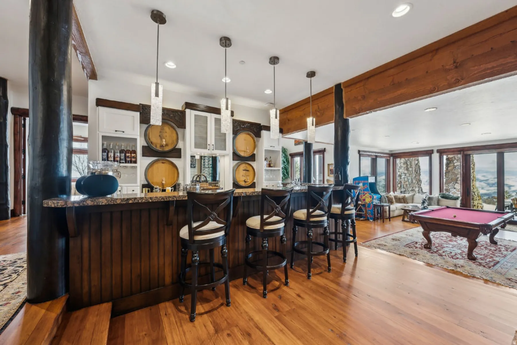 Kitchen featuring billiards, pendant lighting, light wood-style floors, and a kitchen bar