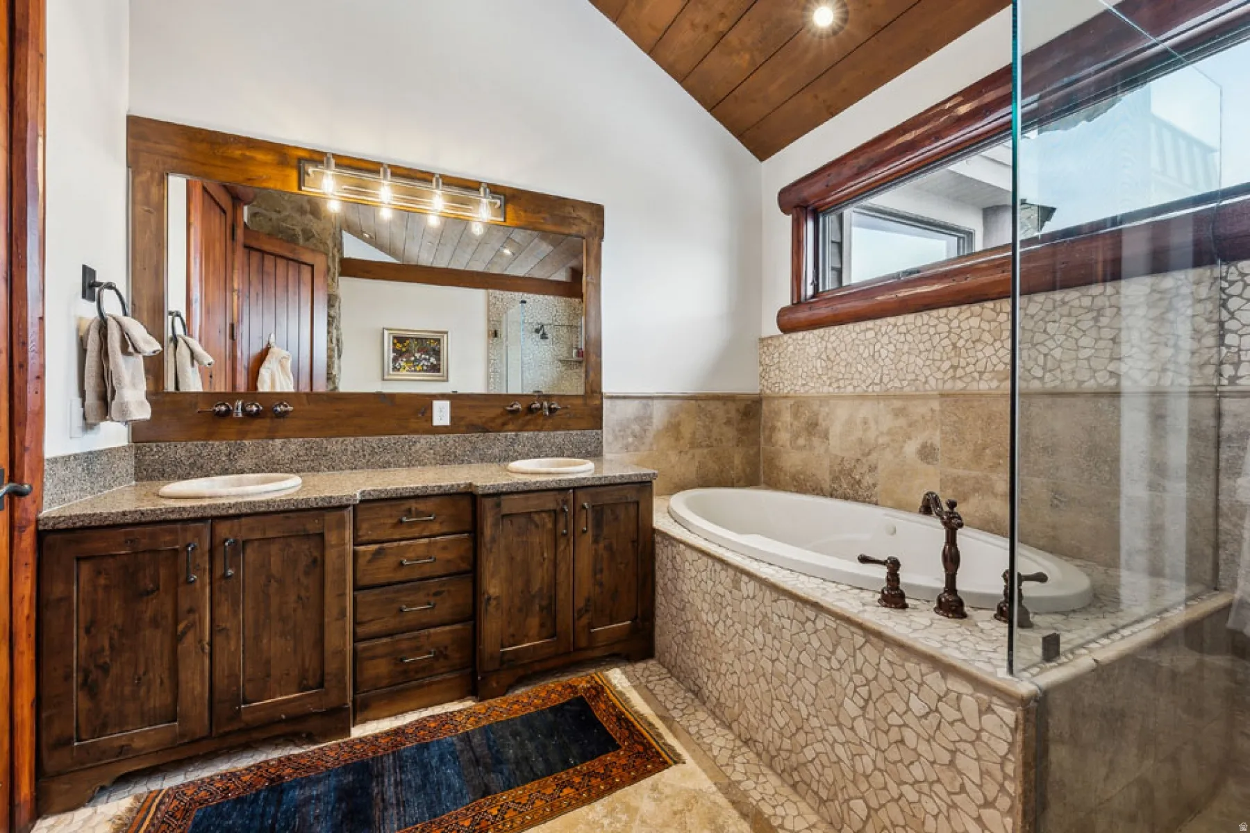 Bathroom with a vaulted wood ceiling, double vanity, a bath, and a shower stall