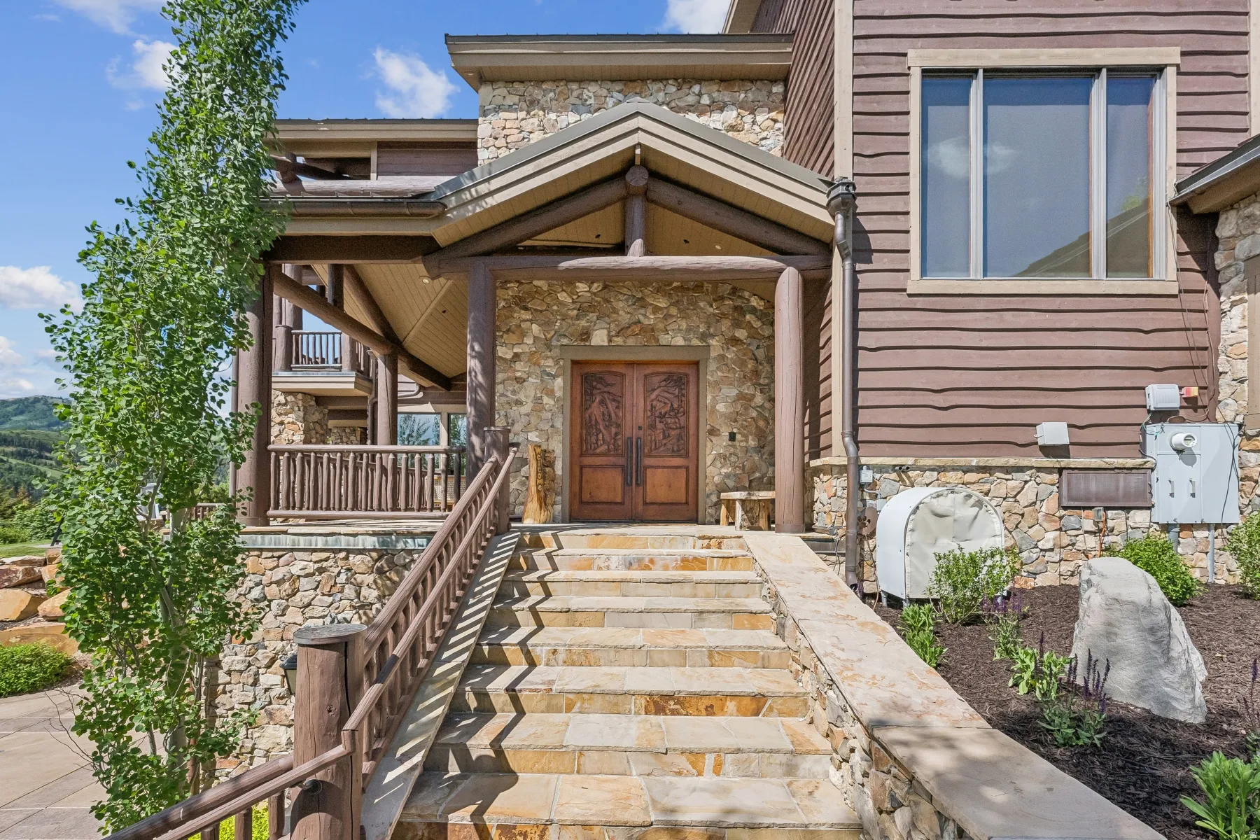 View of exterior entry with stone siding and french doors