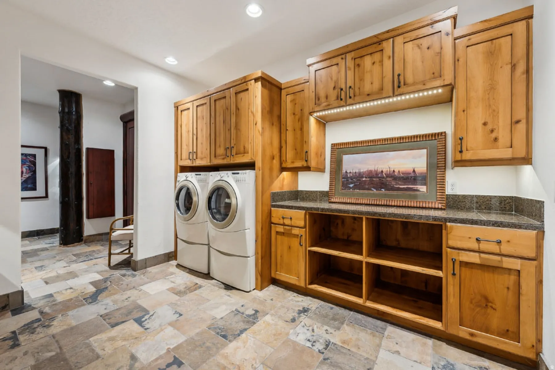 Laundry area featuring recessed lighting, washer and dryer, stone tile flooring, and cabinet space