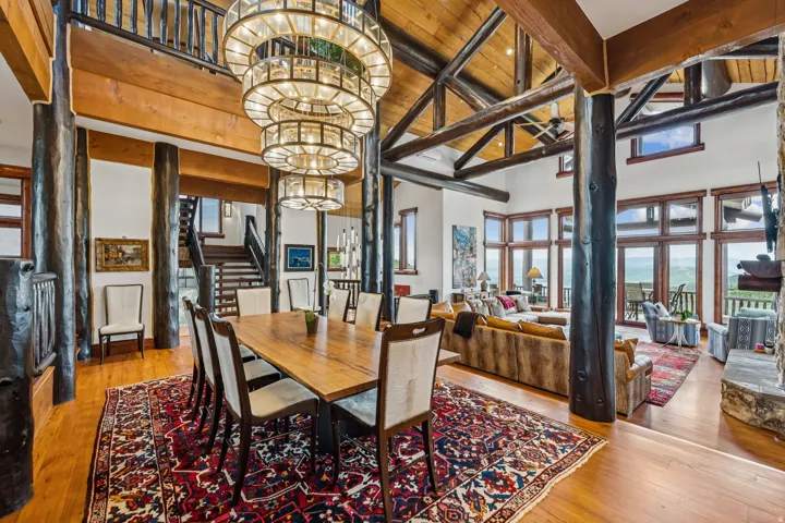 Dining area with light wood-style flooring, hanging lights, and lofted ceiling