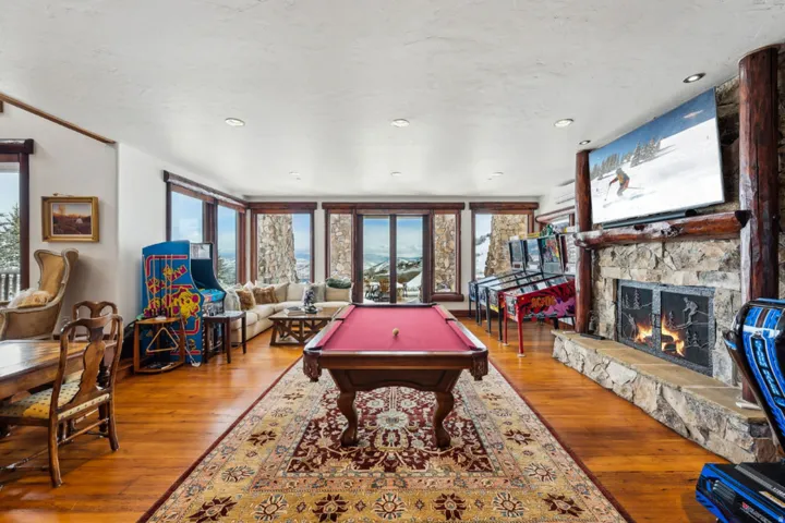 Recreation room with billiards table, wood-type flooring, a stone fireplace, and recessed lighting
