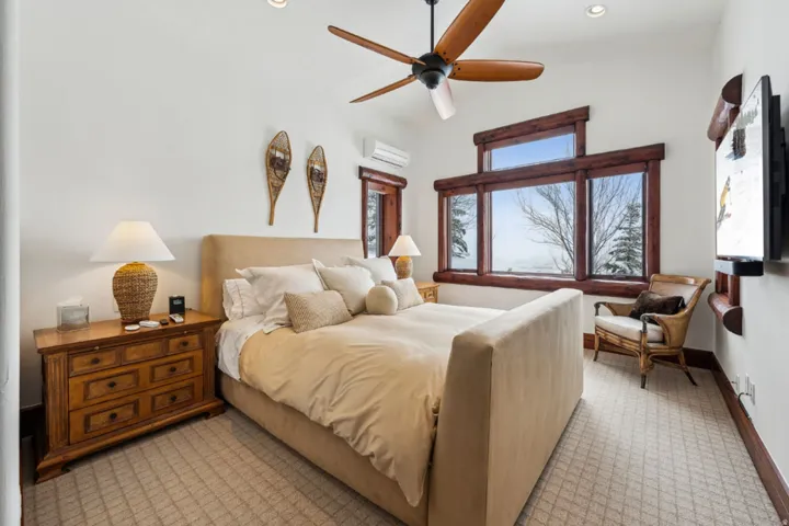 Bedroom with light carpet, a mini split for heating / cooling, and ceiling fan
