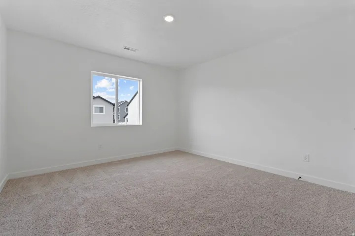 White-painted walls with recessed lighting, a single window, white trim, and neutral carpeting