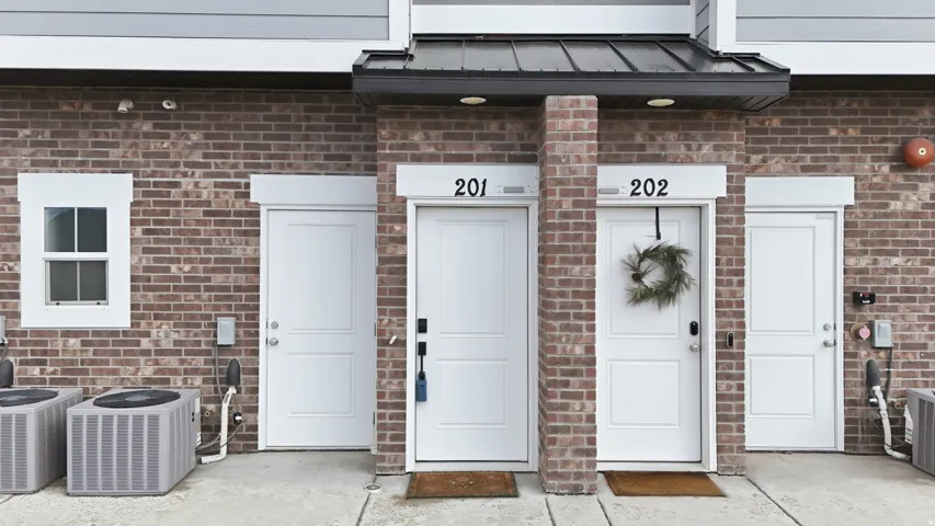 View of exterior entry featuring brick siding and a standing seam roof