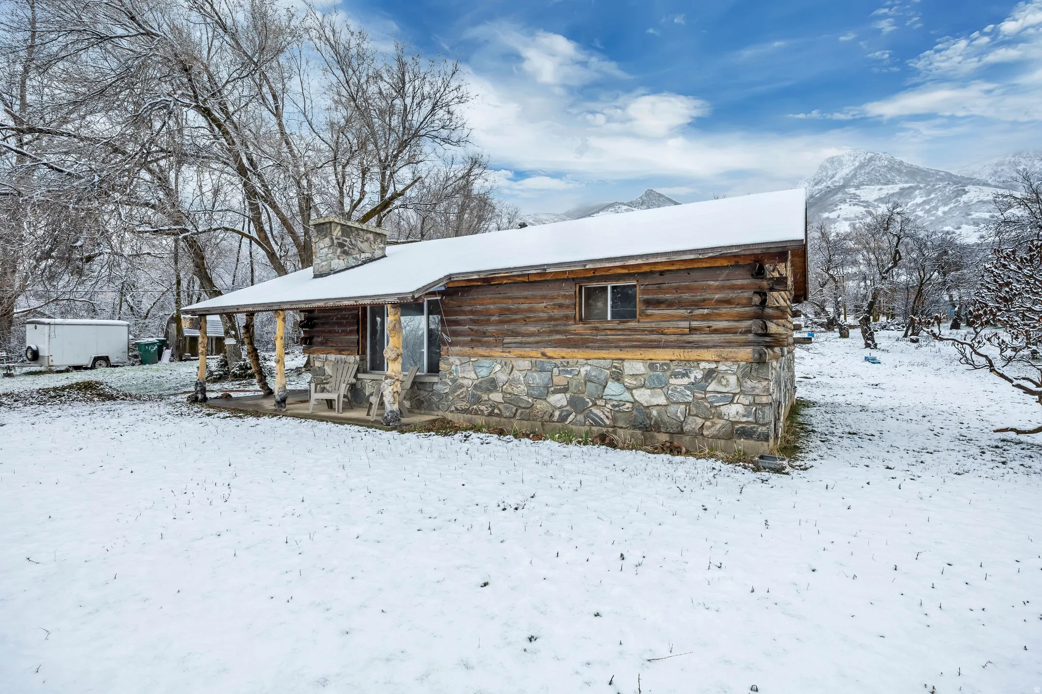 View of front of home with a chimney and log siding
