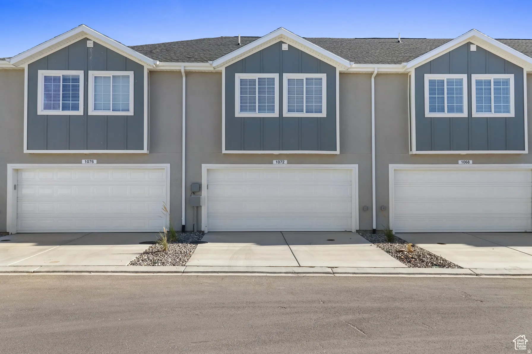 View of front of home featuring board and batten siding, a shingled roof, an attached garage, and concrete driveway
