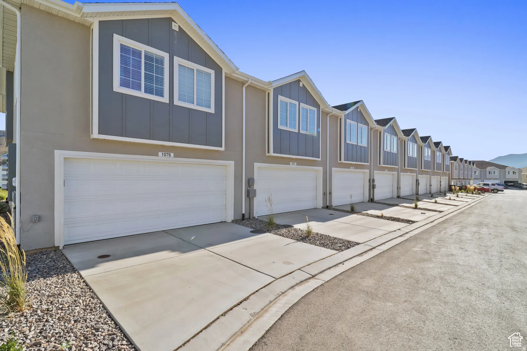 View of front of property featuring board and batten siding, a residential view, concrete driveway, and an attached garage