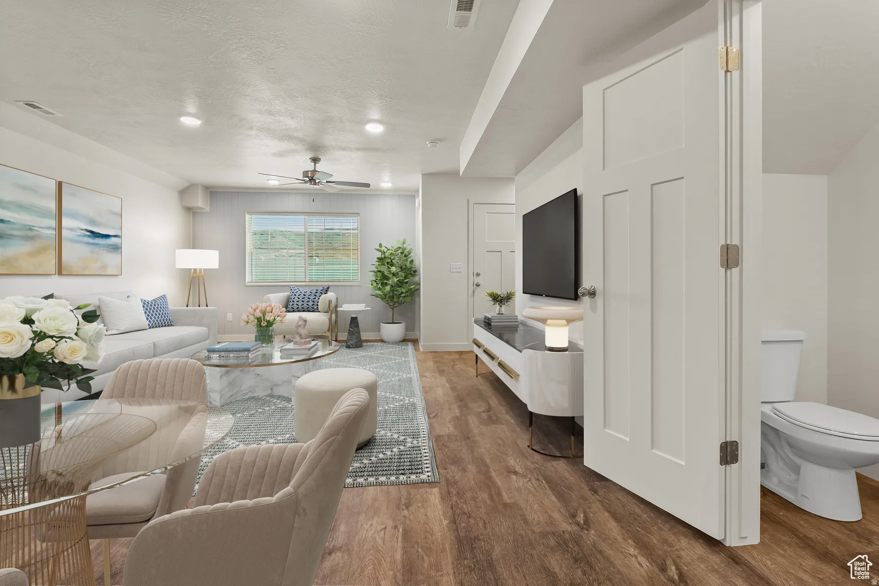Living room with wood finished floors, a ceiling fan, a textured ceiling, and recessed lighting