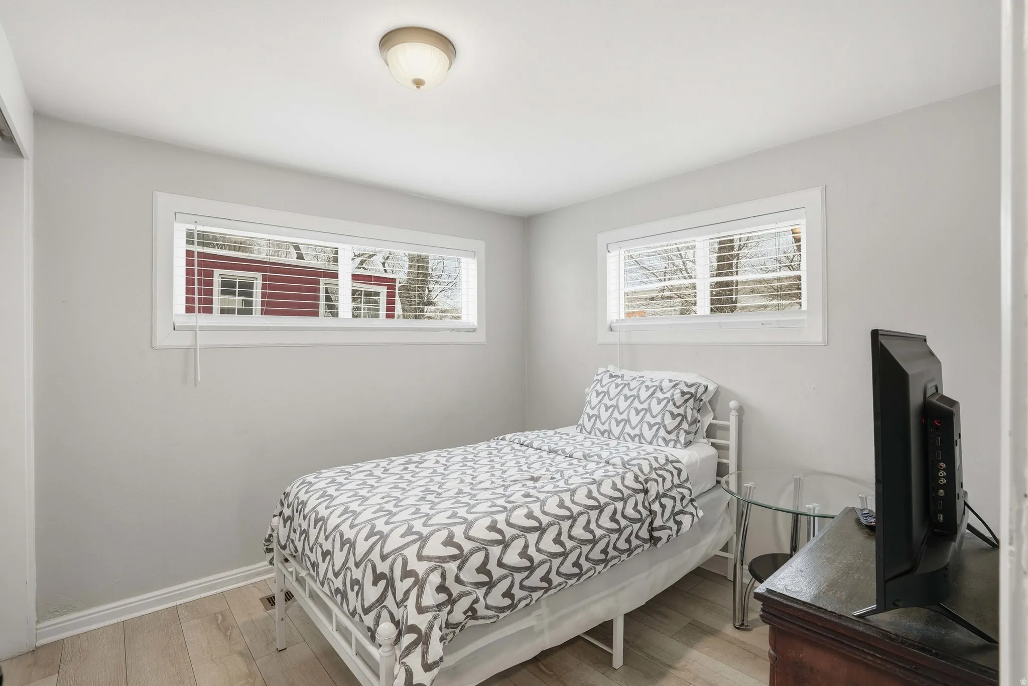 Bedroom with light wood-style flooring and multiple windows