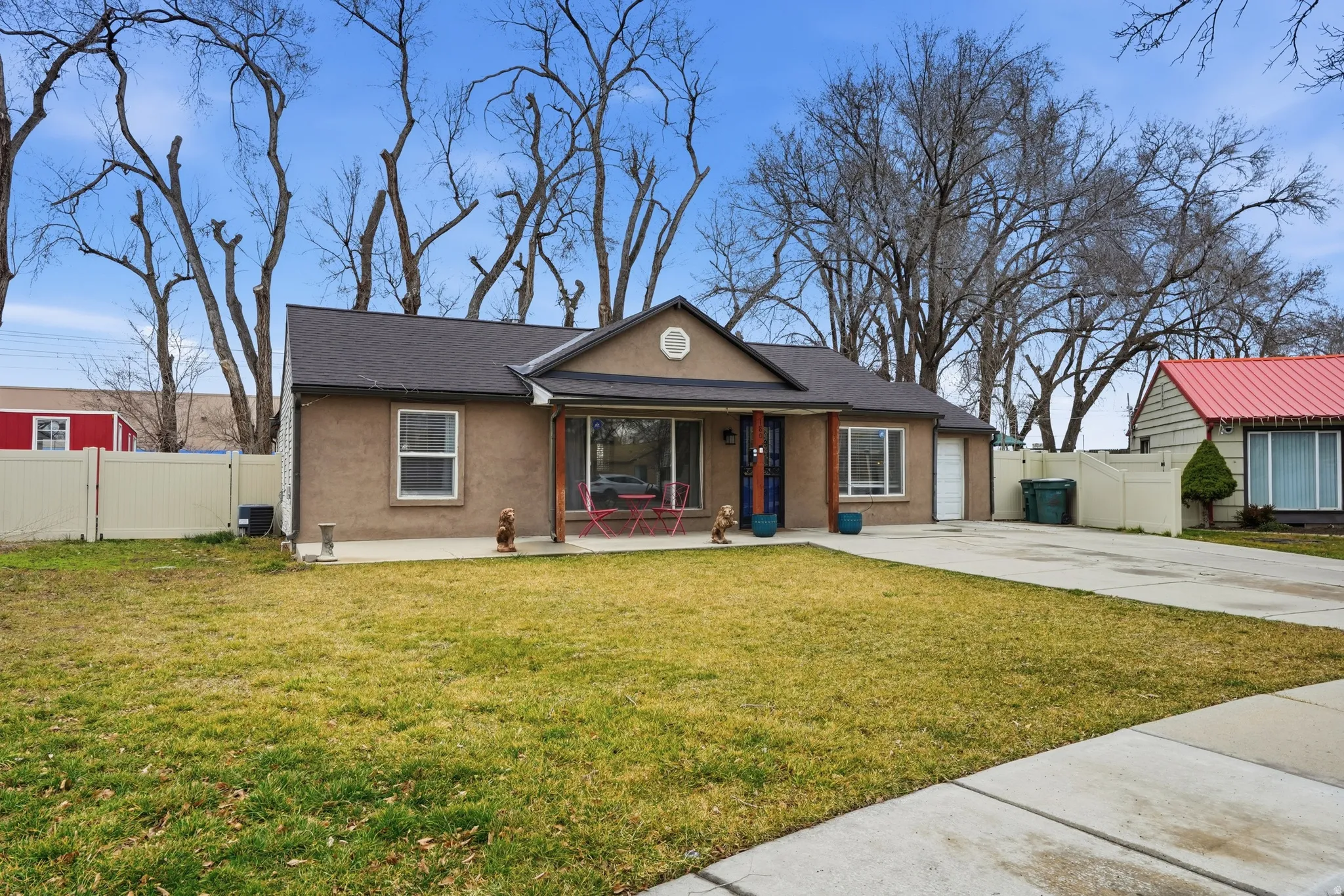 View of front of property featuring stucco siding, a porch, driveway, and a gate