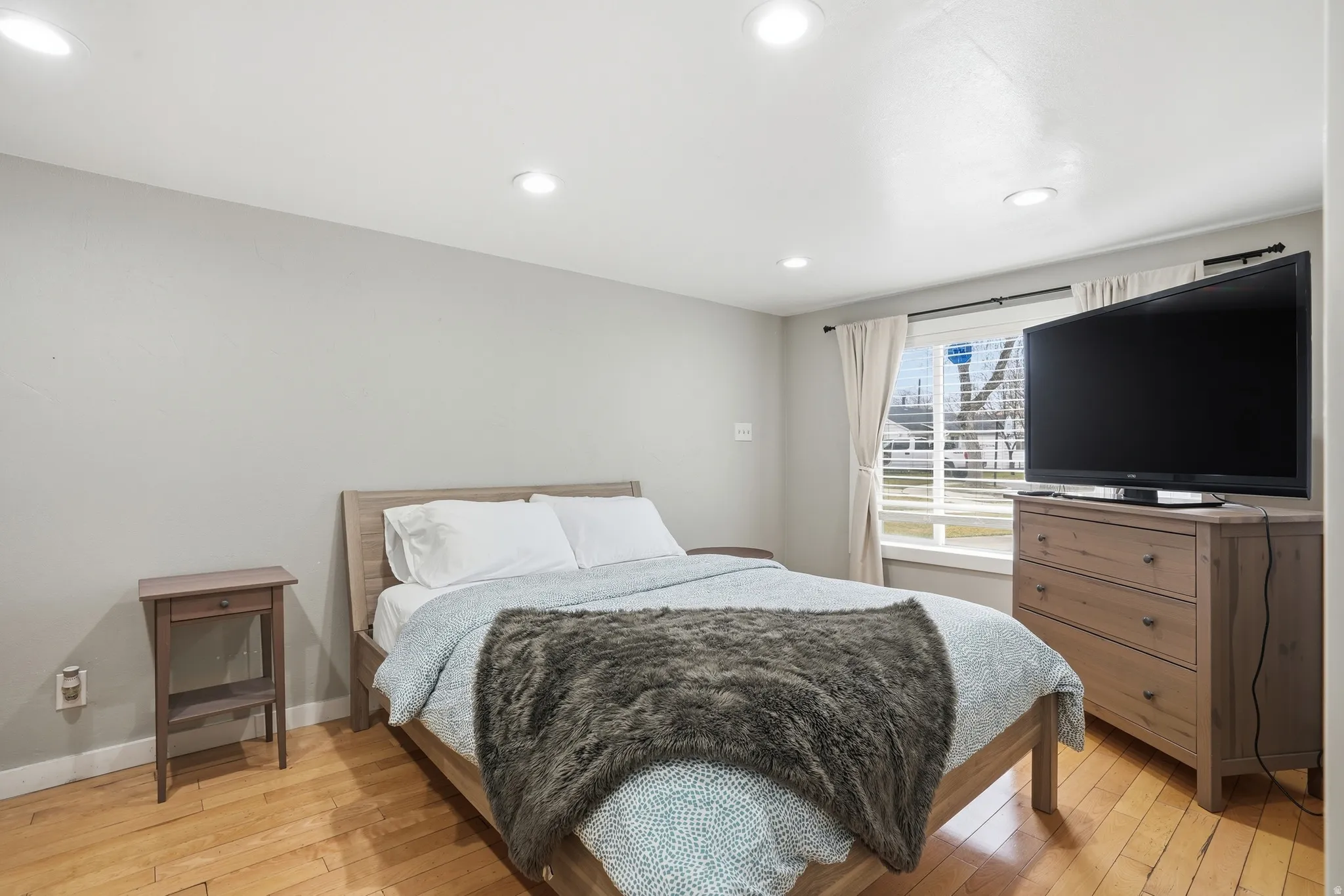 Bedroom with light wood-style floors and recessed lighting