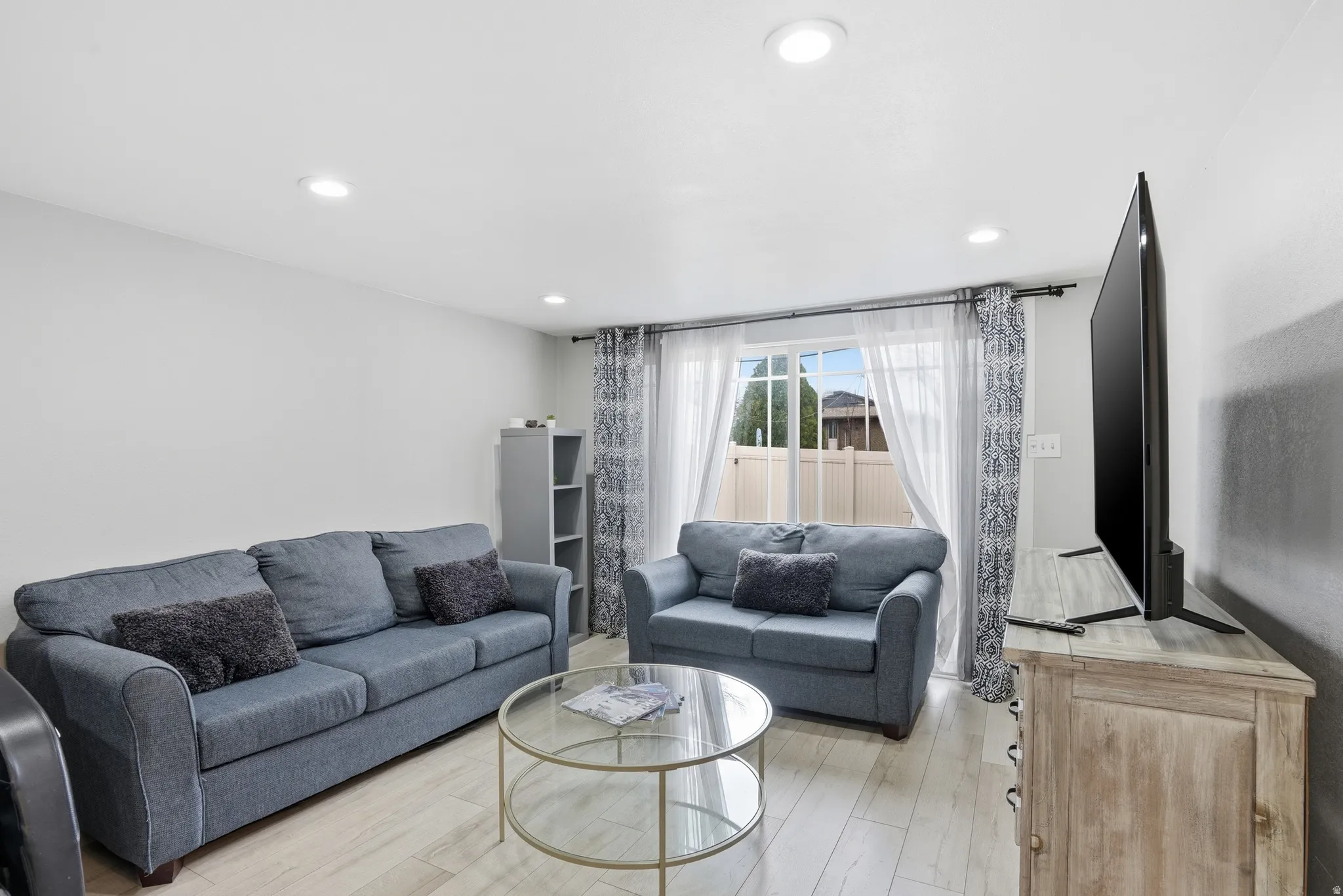 Living room with light wood-style floors and recessed lighting