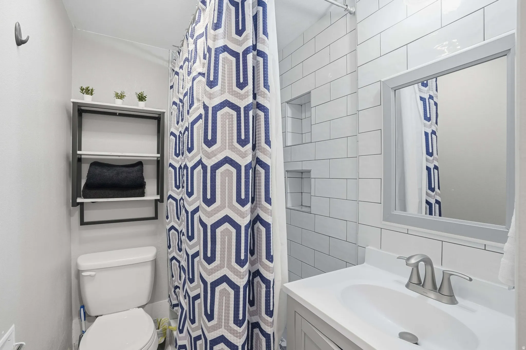 Bathroom featuring vanity, curtained shower, and tile walls