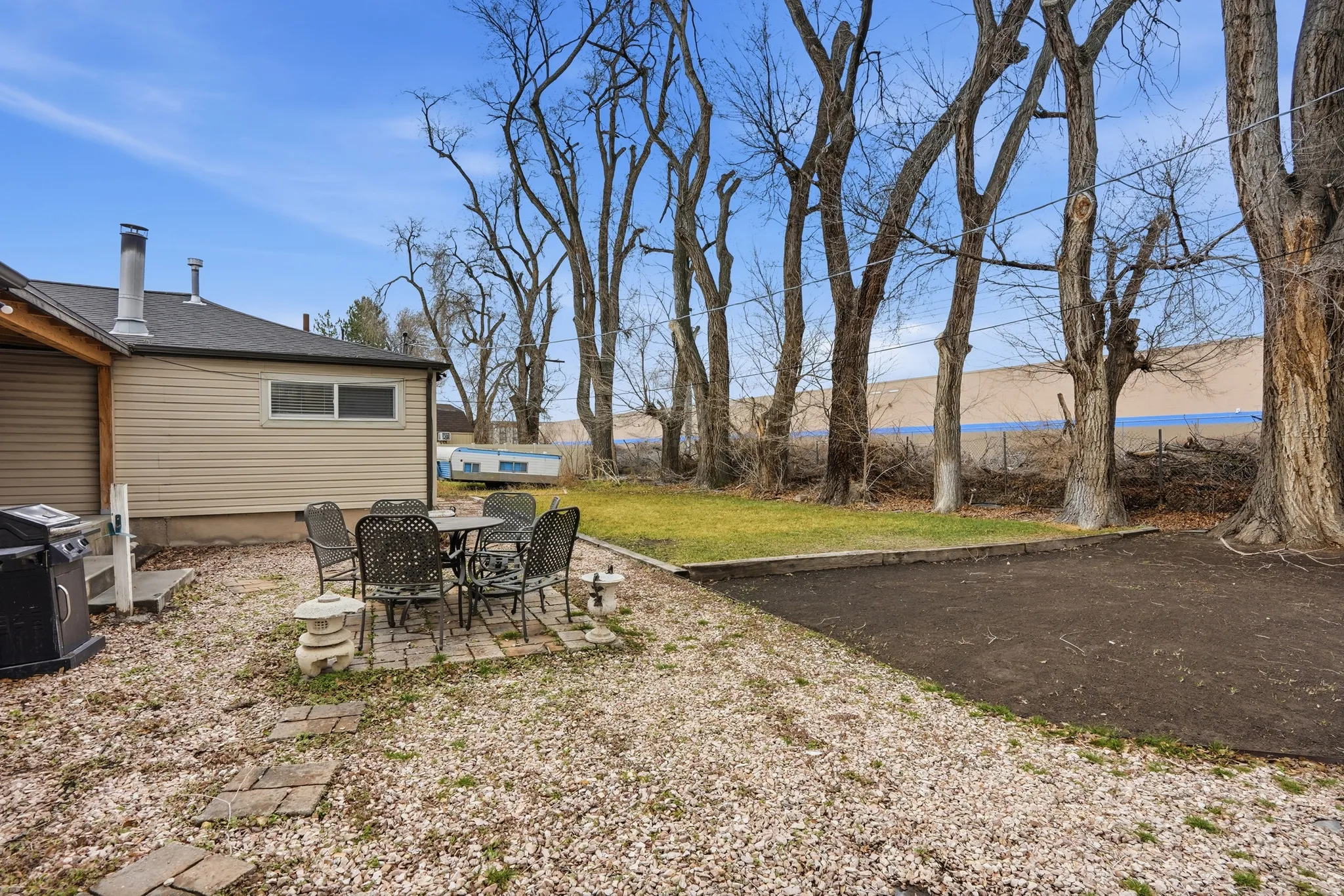 View of green lawn with a patio and outdoor dining space