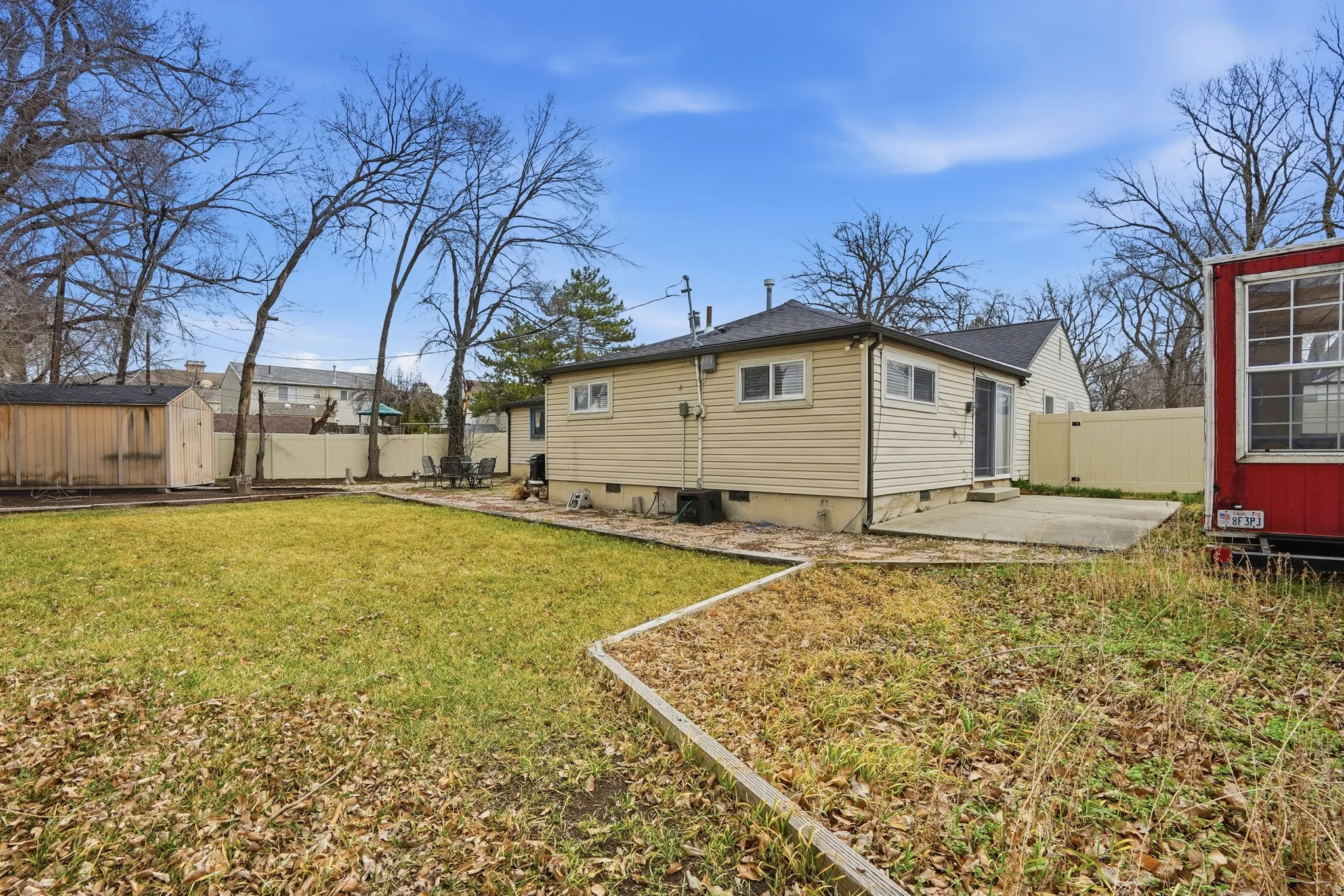 Back of house featuring a patio, a fenced backyard, and a shed