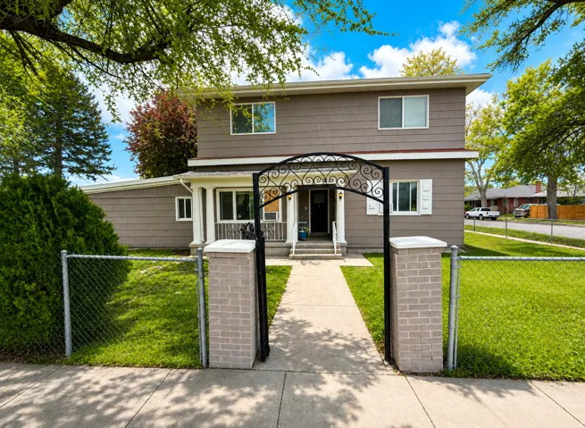 Two-story exterior with neutral siding, white trim, and white window shutters